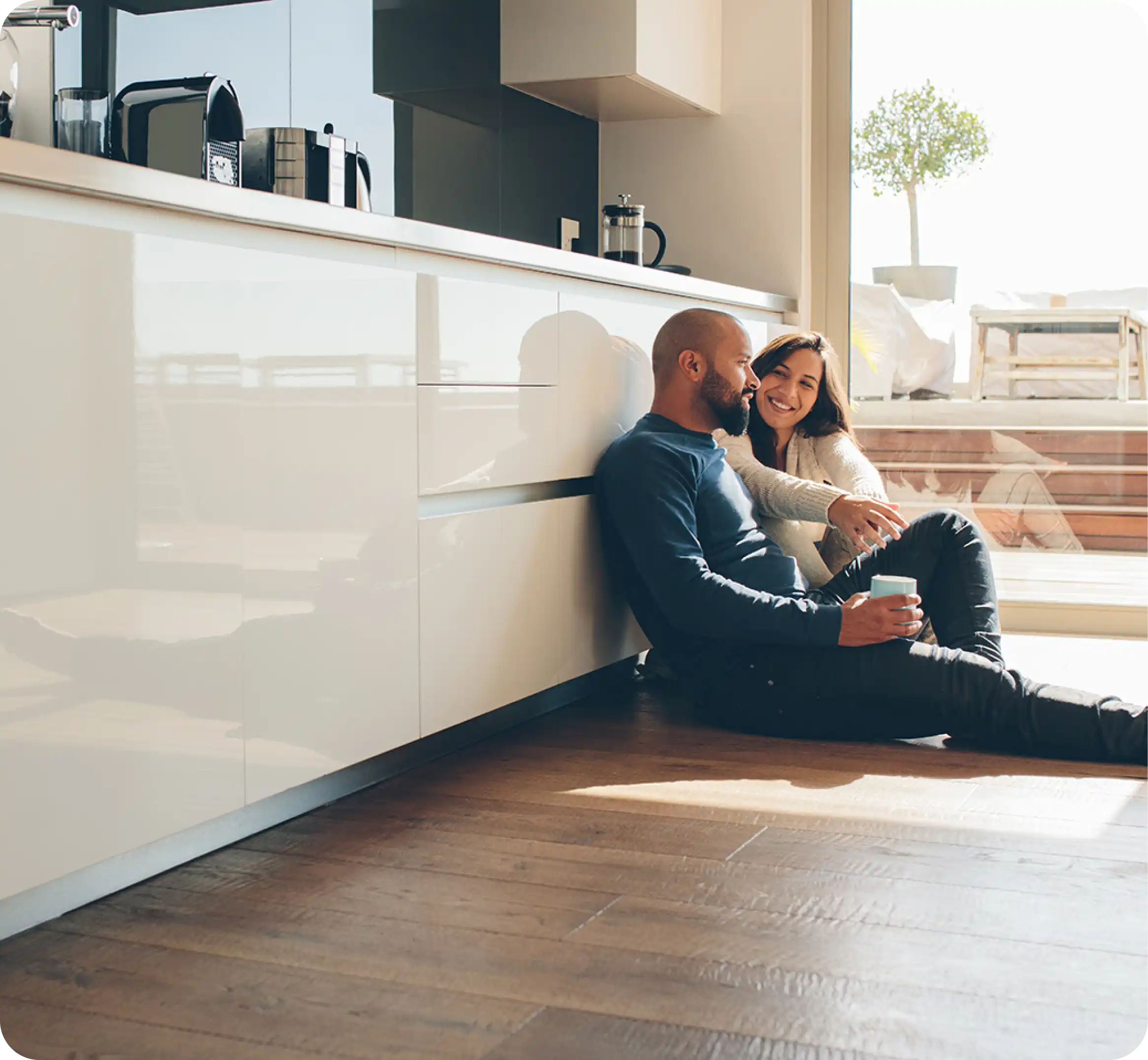 Man en vrouw zitten op vloer in keuken