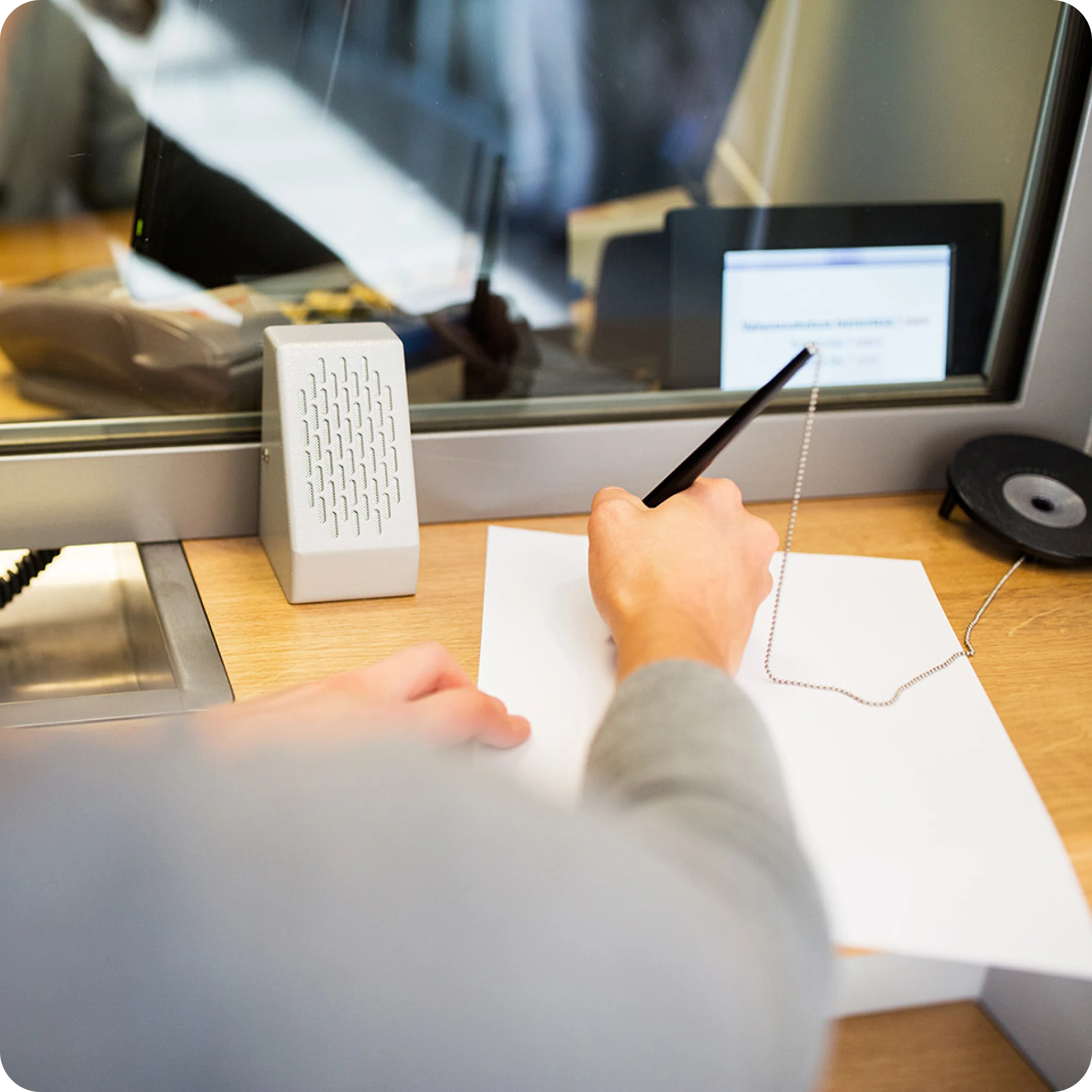 Persoon gebruikt een digitale pen op een grafische tablet in een kantooromgeving.