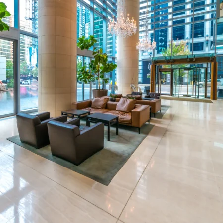 Ruime en luxueuze hotellobby met moderne meubels en grote planten.