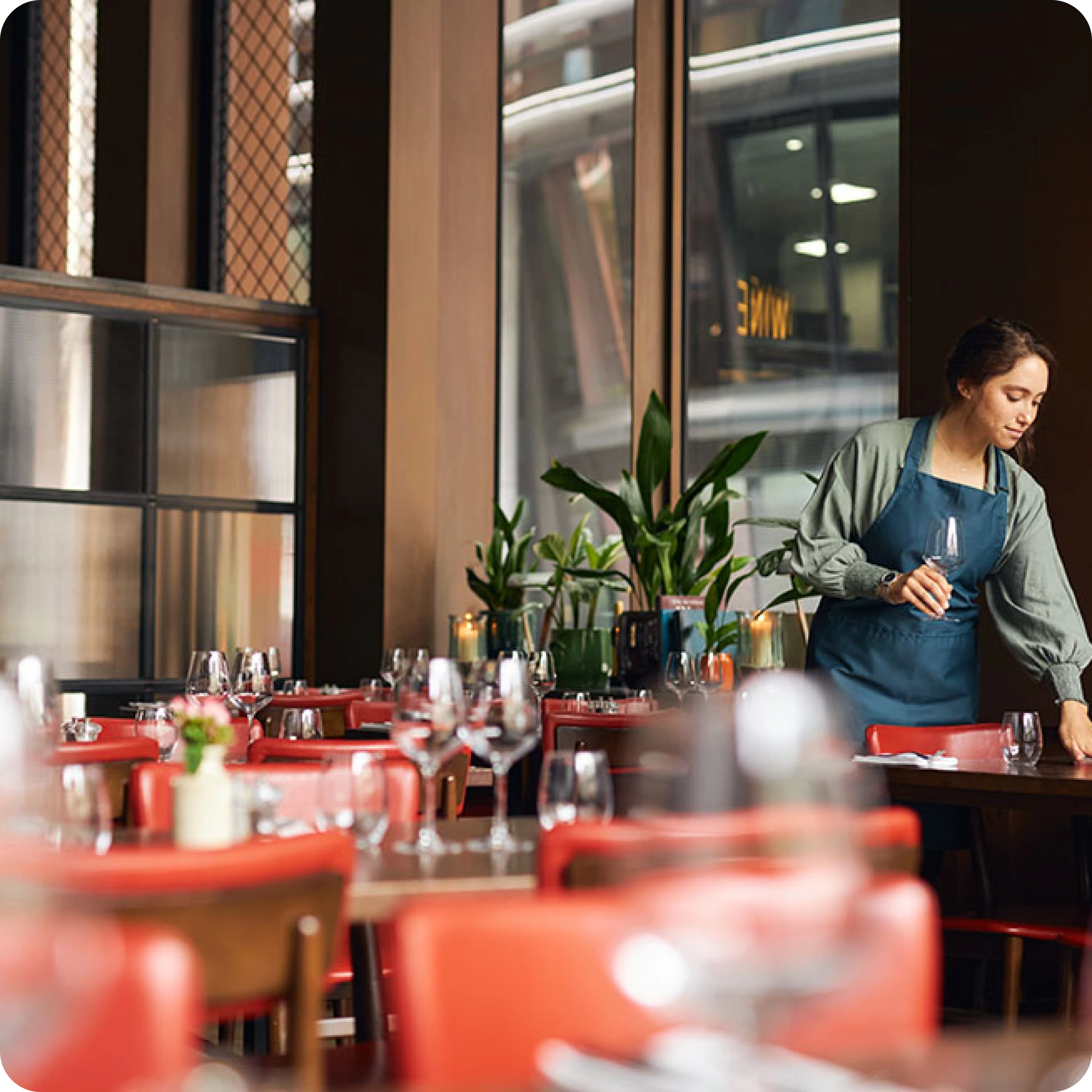 Geur neutraliseren restaurant allsens door effectieve luchtreiniging, een serveerster die een tafel in een schoon restaurant gereedmaakt
