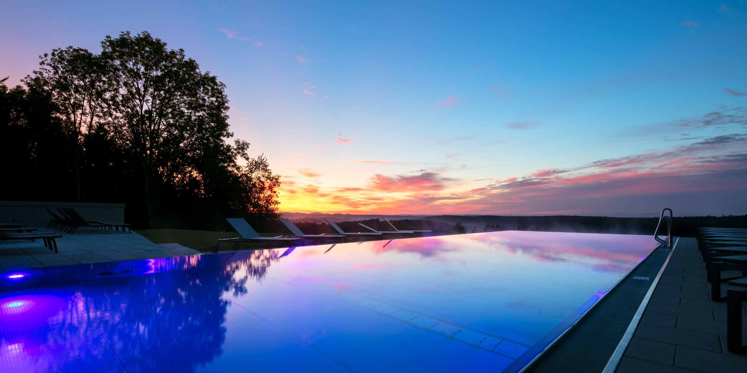Infinity-pool-im-hotel-lauterbad-mit-sonnenuntergang-und-ausblick-auf-den-schwarzwald