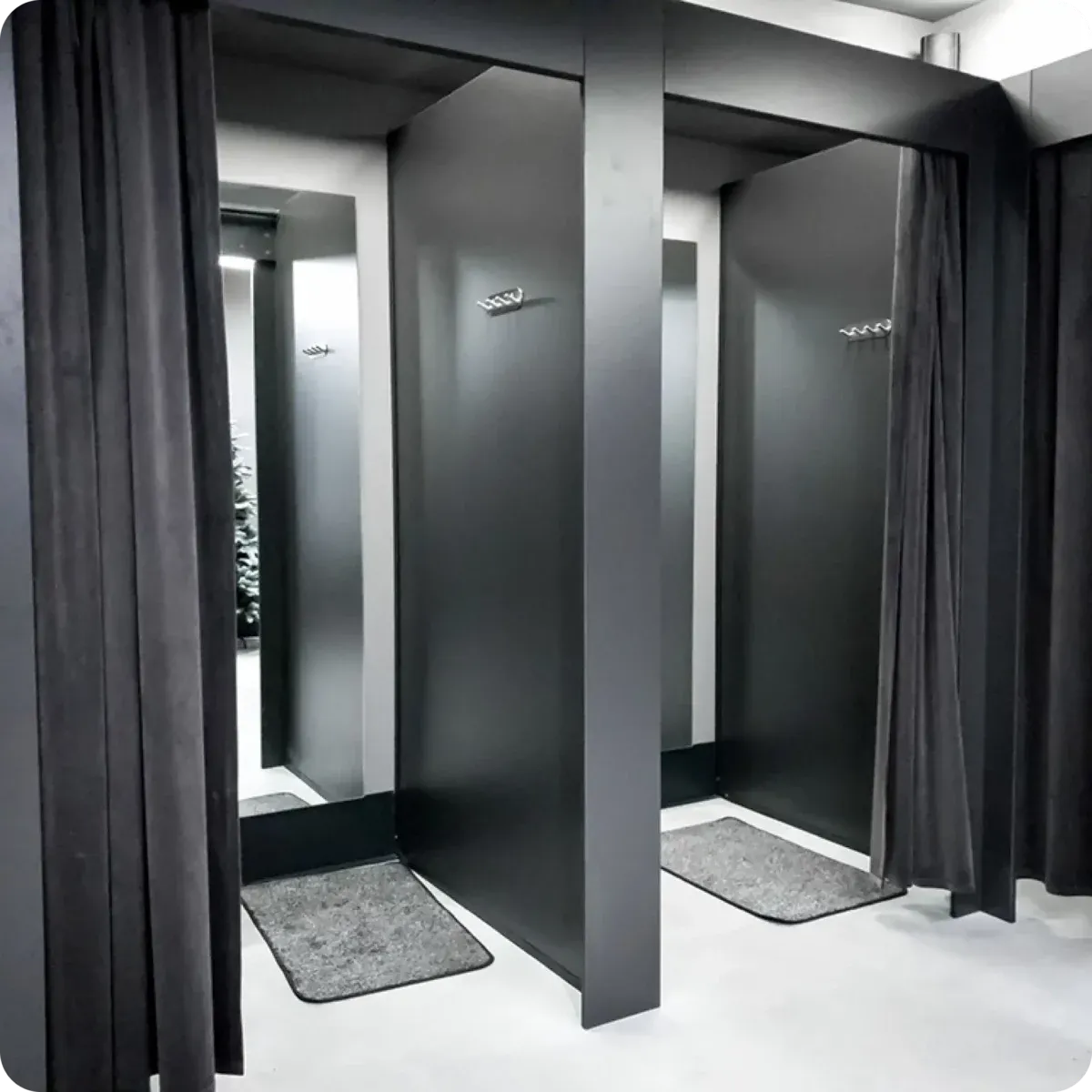 Donkere paskamers met zwarte gordijnen en spiegels, sfeervol verlicht.