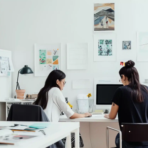 Twee collega’s werken samen in een licht en modern kantoor