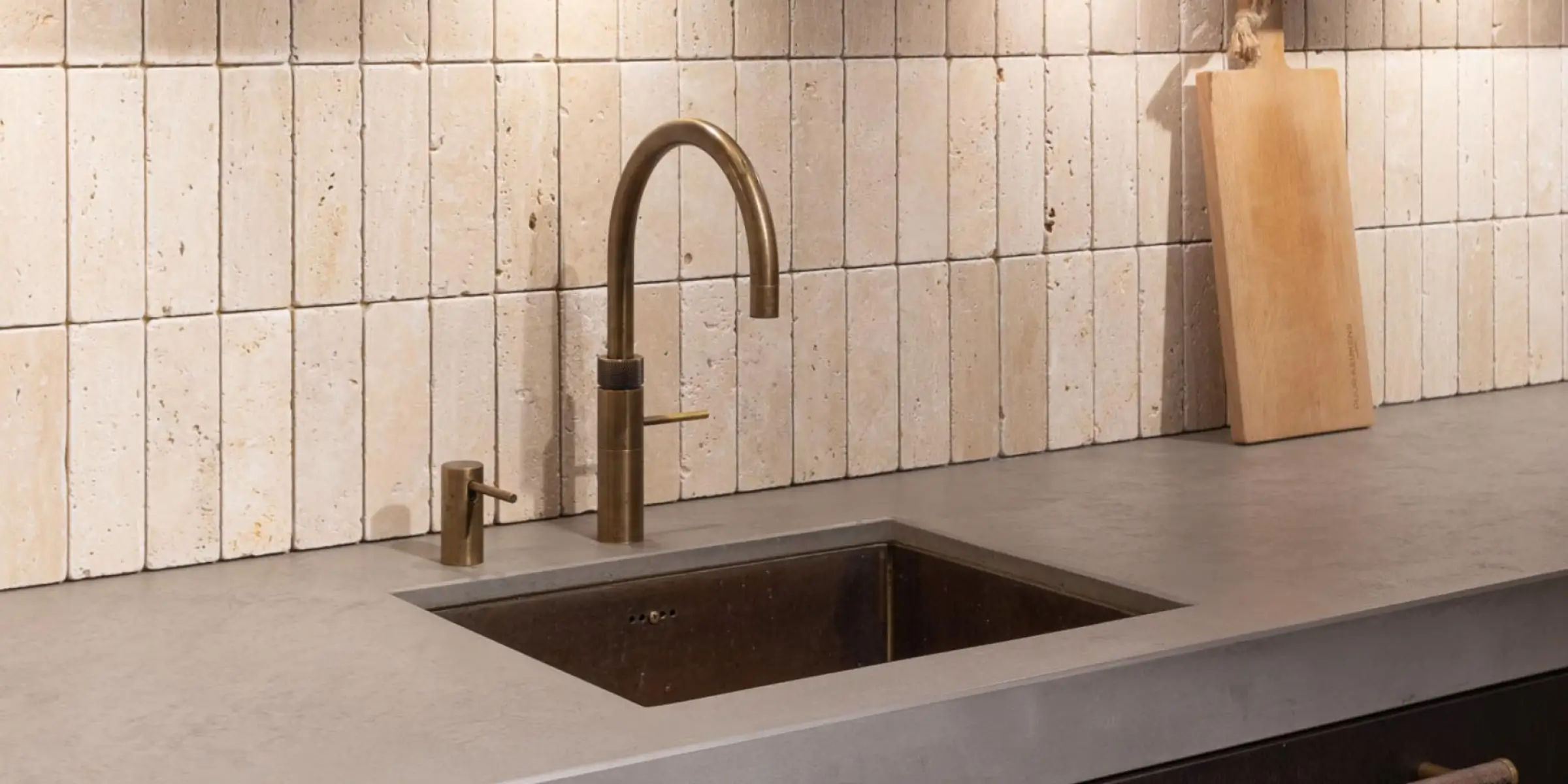 Geurmarketing-keuken-detail-messing-kraan | allsens b. V. Detail van een messing kraan en natuurstenen tegels – subtiele styling die geurmarketing kan aanvullen met zintuiglijke warmte.