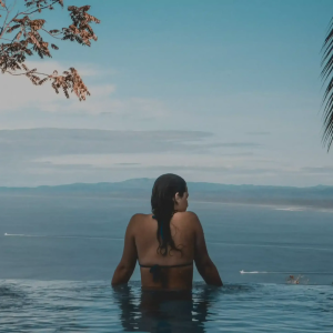 Infinitypool met zeezicht en ontspannen vrouw.
